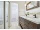 Bathroom featuring double sinks, a wooden framed mirror, and a separate tub and toilet area at 1321 Groveland Ave, Venice, FL 34285