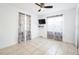 Neutrally decorated bedroom featuring tiled floors, a ceiling fan, and blackout curtains at 1321 Groveland Ave, Venice, FL 34285