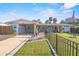 Charming single-story home with a well-manicured lawn, black fence, and a welcoming blue front door at 1321 Groveland Ave, Venice, FL 34285