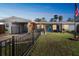 Charming single-story home with a well-manicured lawn, black fence, and a welcoming blue front door at 1321 Groveland Ave, Venice, FL 34285