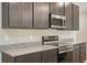 Close-up of kitchen with stainless steel microwave and oven, granite counters and dark brown wood cabinets at 25172 Calusa Dr, Punta Gorda, FL 33955