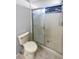 Bathroom showcasing tiled shower with glass door and neutral tile flooring at 3402 Rankin Dr, New Port Richey, FL 34655