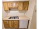 Galley kitchen with wood cabinets, tile flooring, stainless steel sink, and white dishwasher at 4034 Dream Oak Pl # 104, Tampa, FL 33613