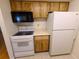 The kitchen features white appliances and wood cabinets, maximizing space and functionality at 4034 Dream Oak Pl # 104, Tampa, FL 33613