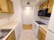 The kitchen overlooks the hallway and features a dishwasher, wood cabinets and white appliances at 4034 Dream Oak Pl # 104, Tampa, FL 33613