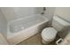 Bathroom featuring a tub with tile surround and a white toilet at 7502 Needle Leaf Pl # B66, Tampa, FL 33617