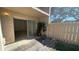 Outdoor patio with tile, wooden fence, and a peek into the main living area at 7502 Needle Leaf Pl # B66, Tampa, FL 33617