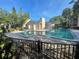 Bright community pool with a blue tiled edge surrounded by brick, trees, and a fenced-in enclosure at 7502 Needle Leaf Pl # B66, Tampa, FL 33617