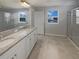 A bright bathroom with double vanity, granite countertop, and a glass enclosed shower at 6525 Dutton Dr, Wesley Chapel, FL 33545