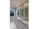 A bright bathroom with double vanity with granite countertop, a large mirror, and modern lighting at 6525 Dutton Dr, Wesley Chapel, FL 33545