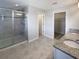 Contemporary bathroom features a glass-enclosed shower and dual granite-topped vanities at 6525 Dutton Dr, Wesley Chapel, FL 33545