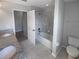 A bright bathroom features a shower and tub combination, tile surround, and a separate toilet at 6525 Dutton Dr, Wesley Chapel, FL 33545