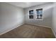 Bedroom with neutral carpet and two windows at 6525 Dutton Dr, Wesley Chapel, FL 33545