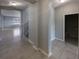 Bright entryway featuring tile floors, access to the living area, staircase, and bathroom, with a neutral color palette at 6525 Dutton Dr, Wesley Chapel, FL 33545