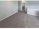 A carpeted hallway with neutral walls and a view into another room provides open access at 6525 Dutton Dr, Wesley Chapel, FL 33545