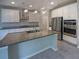 Modern kitchen featuring stainless steel appliances, granite countertops, a large island, and white cabinetry at 6525 Dutton Dr, Wesley Chapel, FL 33545
