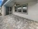 Spacious, covered patio with a ceiling fan, sliding glass door and three large windows overlooking the backyard at 6525 Dutton Dr, Wesley Chapel, FL 33545