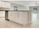 Kitchen island with dark countertop and white cabinets at 13507 Willow Bluestar Loop, Riverview, FL 33579