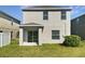 Green backyard with sliding glass doors, a small patio, and a lush green lawn at 2313 Richwood Pike Dr, Ruskin, FL 33570