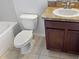 Compact bathroom featuring a toilet and a vanity with a sink, set against neutral tiles at 2313 Richwood Pike Dr, Ruskin, FL 33570