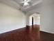 Bright living room with ceiling fan, cherry-wood floors, and arched doorway leading to other rooms at 3328 Circleville St, North Port, FL 34286