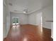 Bright living room with hardwood floors, ceiling fan, and sliding doors to the lanai, filling the space with natural light at 3328 Circleville St, North Port, FL 34286