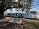 Backyard featuring a mature tree, patio table, and plenty of space for relaxation and entertainment at 5125 Janice Ln, Holiday, FL 34690