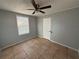 Bedroom features tile flooring, ceiling fan, fresh paint, and a window for natural light at 5125 Janice Ln, Holiday, FL 34690