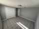 Neutral-colored bedroom with tile flooring, large closet doors, and overhead lighting at 5125 Janice Ln, Holiday, FL 34690