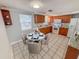 Cozy kitchen with a dining area featuring a marble table, wood cabinetry, and abundant natural light at 5125 Janice Ln, Holiday, FL 34690