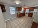 Cozy kitchen featuring tile floors, granite countertops, white appliances, and wood cabinets at 5125 Janice Ln, Holiday, FL 34690