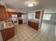 Well-lit kitchen with white appliances, wood cabinets, granite countertops, and tile flooring at 5125 Janice Ln, Holiday, FL 34690