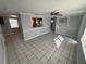 Spacious living room with tile floors, neutral paint, and a clear view into the kitchen at 5125 Janice Ln, Holiday, FL 34690