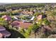 Aerial view of a condo community with mature trees, covered parking, and red roofs at 1801 E Lake Rd # 3A, Palm Harbor, FL 34685