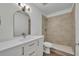 This bathroom has a single sink vanity, a sleek mirror, a toilet, and a modern, tiled walk-in shower at 4522 Marine Pkwy, New Port Richey, FL 34652