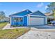 Charming blue home with a two-car garage, a well-manicured lawn, and lovely landscaping at 4522 Marine Pkwy, New Port Richey, FL 34652