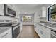 Updated kitchen features stainless steel appliances, granite countertops, and sleek white cabinets at 4522 Marine Pkwy, New Port Richey, FL 34652