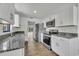 Modern kitchen featuring granite countertops, stainless steel appliances, and white cabinets at 4522 Marine Pkwy, New Port Richey, FL 34652