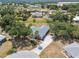 An aerial view showcases the property's location, mature trees, extended driveway and proximity to nearby homes at 26058 Paysandu Dr, Punta Gorda, FL 33983
