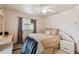 Cozy bedroom with a comfortable bed, ceiling fan, and a window with decorative curtains at 26058 Paysandu Dr, Punta Gorda, FL 33983