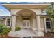 Inviting front entrance featuring double doors, columns, an archway, and manicured landscaping at 26058 Paysandu Dr, Punta Gorda, FL 33983