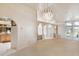 Spacious living room featuring neutral carpet, archways, columns, and access to the kitchen at 26058 Paysandu Dr, Punta Gorda, FL 33983