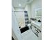 Bathroom features a modern vanity, a toilet, a shower with a curtain and white tile flooring at 9151 Bay Dr, Spring Hill, FL 34606