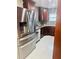 Modern kitchen with stainless steel appliances, dark cabinets, mosaic backsplash, and granite countertops at 9151 Bay Dr, Spring Hill, FL 34606
