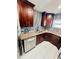 Modern kitchen features dark cabinetry, granite countertops, stainless steel appliances, and a decorative backsplash at 9151 Bay Dr, Spring Hill, FL 34606