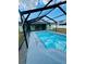 View of the pool in a screened-in enclosure, providing a private and comfortable swimming experience at 9151 Bay Dr, Spring Hill, FL 34606