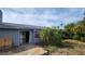 Exterior backyard of a house with a covered patio, boarded window, and overgrown vegetation at 5109 19Th W St, Bradenton, FL 34207