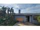 Exterior view of a home with a chimney, sliding glass doors, and boarded up windows at 5109 19Th W St, Bradenton, FL 34207