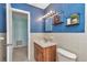 Bathroom with blue textured wallpaper and white tile at 6417 Driftwood Dr, Hudson, FL 34667