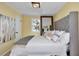 Bedroom featuring a tufted headboard, neutral tones, and a large decorative mirror at 6417 Driftwood Dr, Hudson, FL 34667